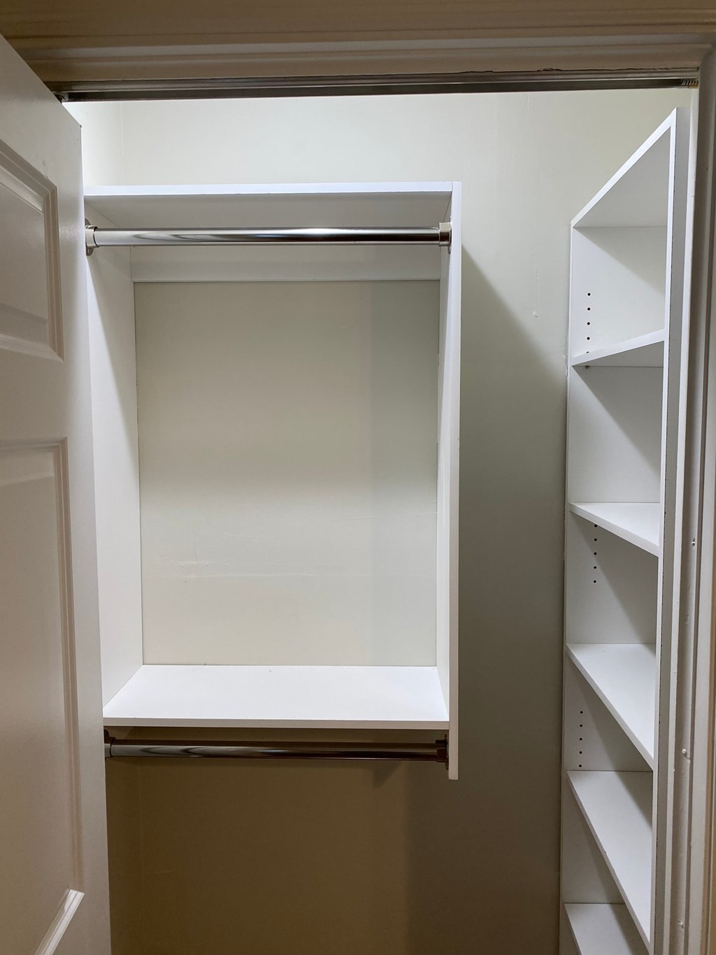 a walk in closet with an open shelving unit