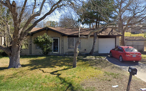 a house with a red car parked in front of it