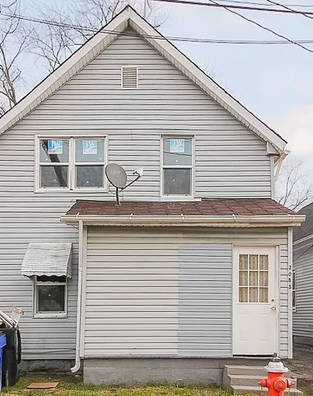 A house with a grey siding and a white door.