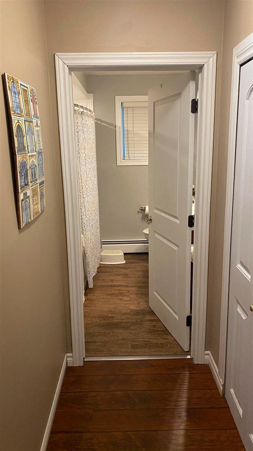 a small hallway with a door open to a bathroom