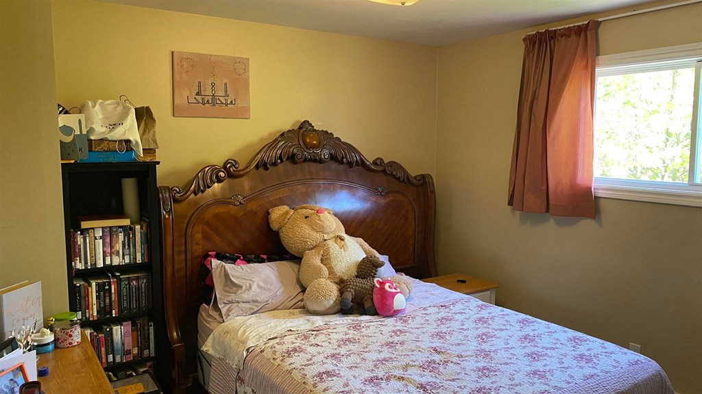 a bedroom with a bed with a teddy bear on it