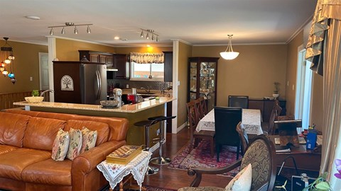 a living room and kitchen with a couch and a piano