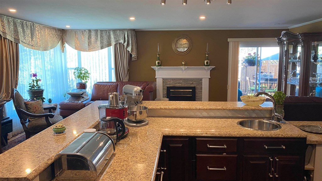 a kitchen with a counter top and a living room with a fireplace