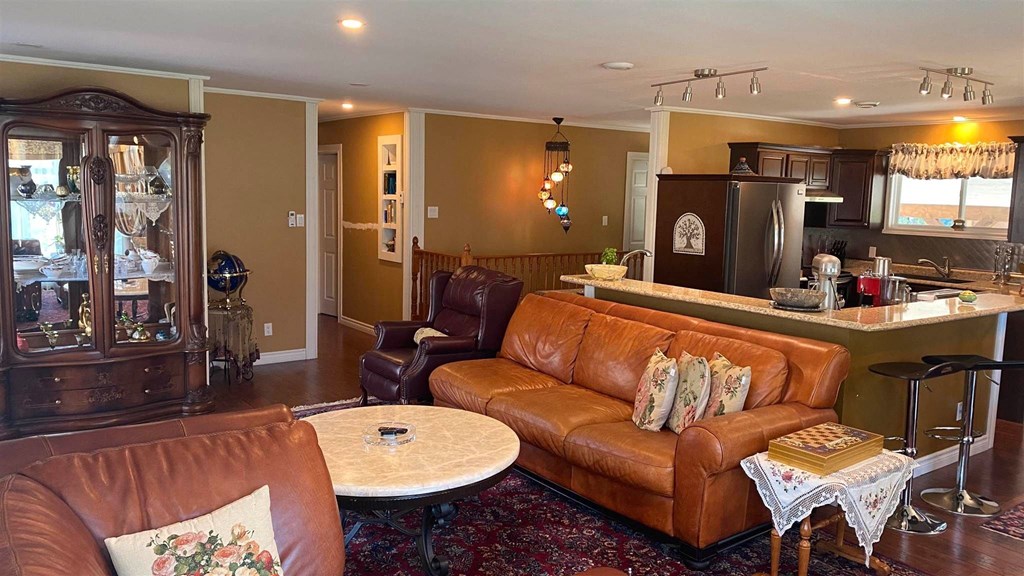 a living room with leather furniture and a kitchen with a bar