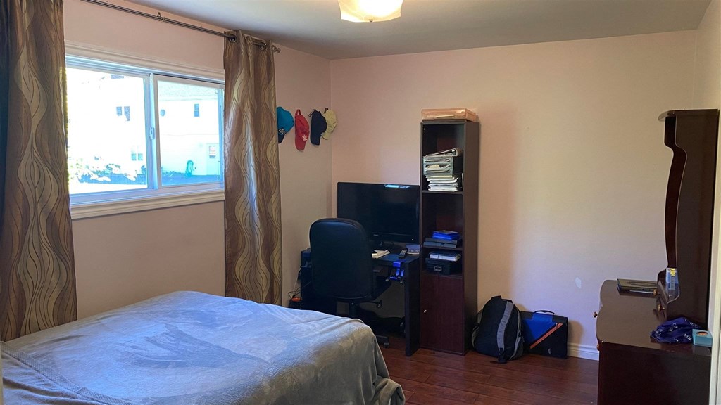 a bedroom with a bed and a desk and a window