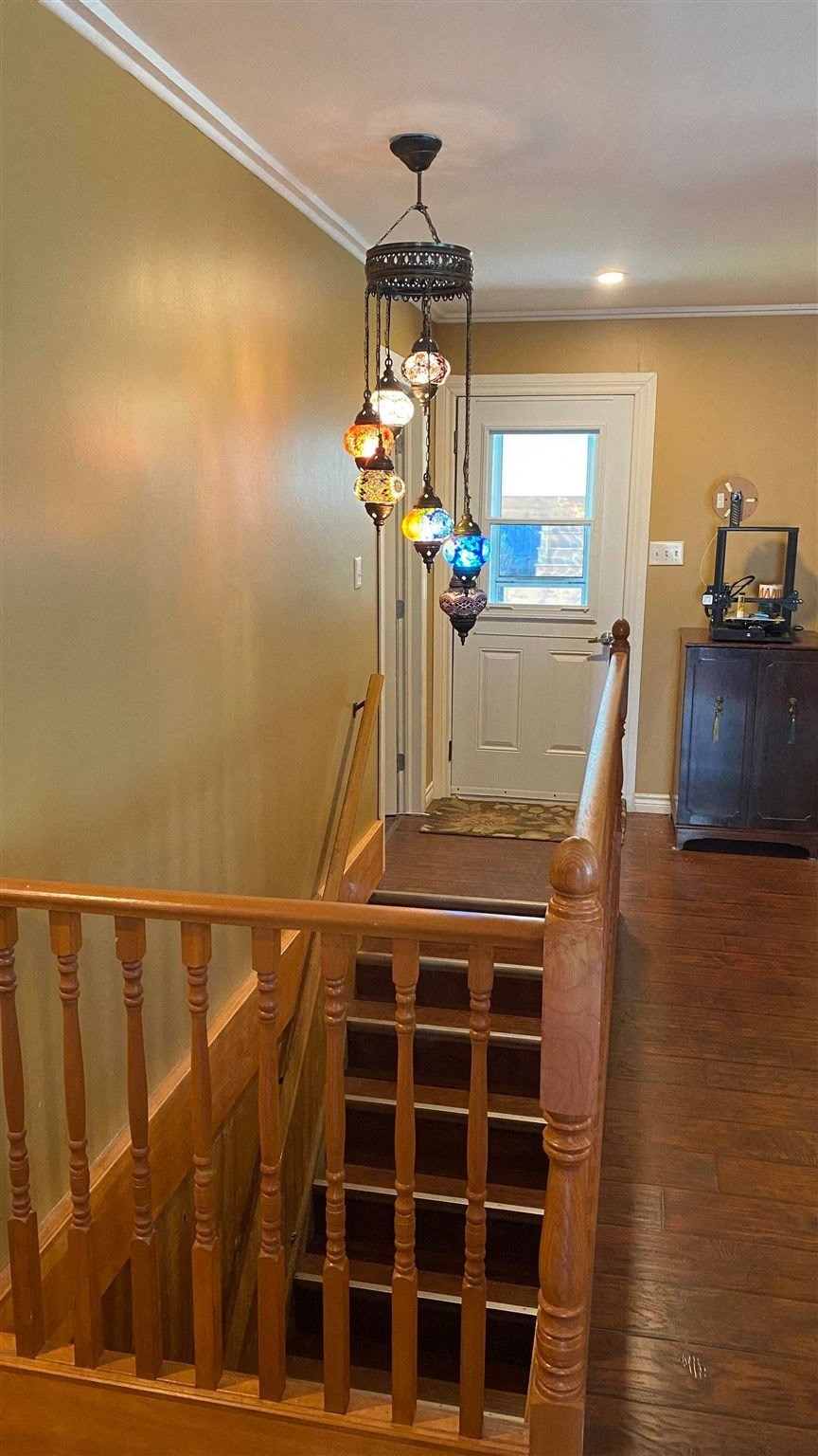 a hallway with stairs and a chandelier