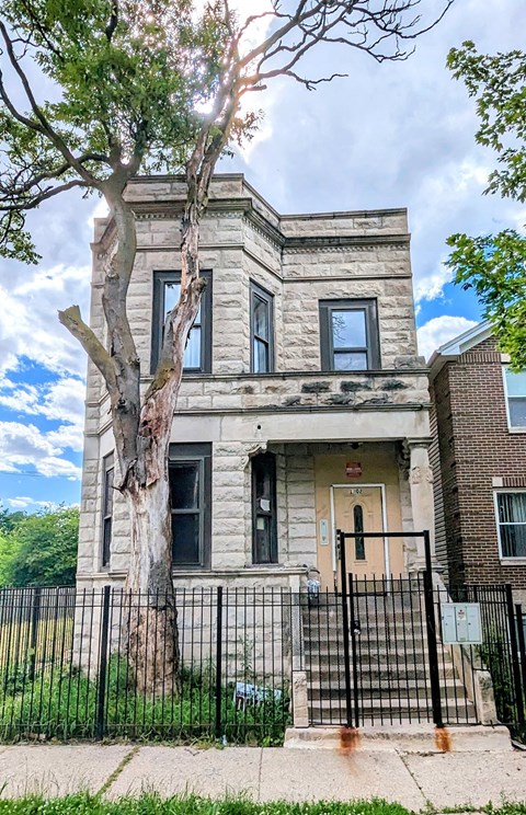 A large, old house with a tree in front of it.