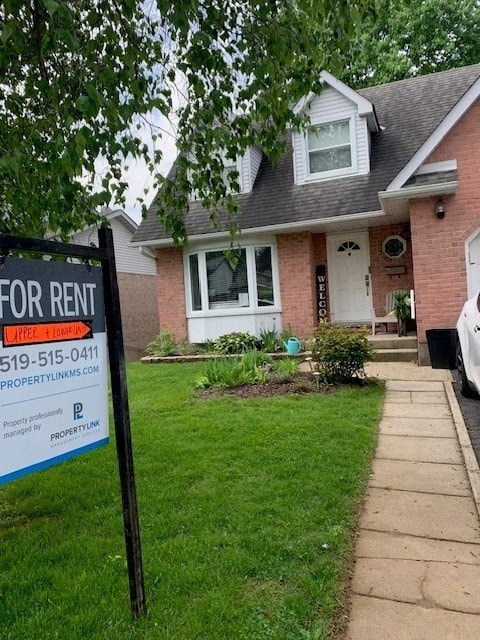 a house with a for rent sign in front of it