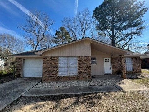 a brick house with a white door and a driveway
