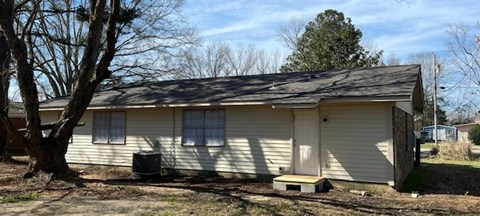 a white house with a tree in front of it