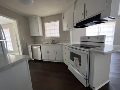 an empty kitchen with white appliances and white cabinets