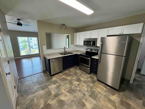 a kitchen with stainless steel appliances and white cabinets