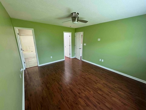a empty living room with green walls and a wooden floor