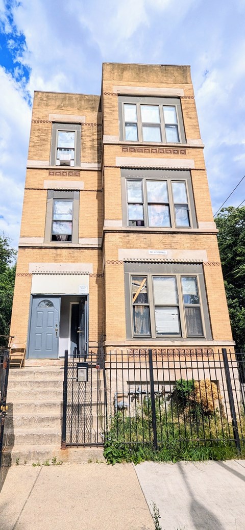 A brown building with a blue door and windows.