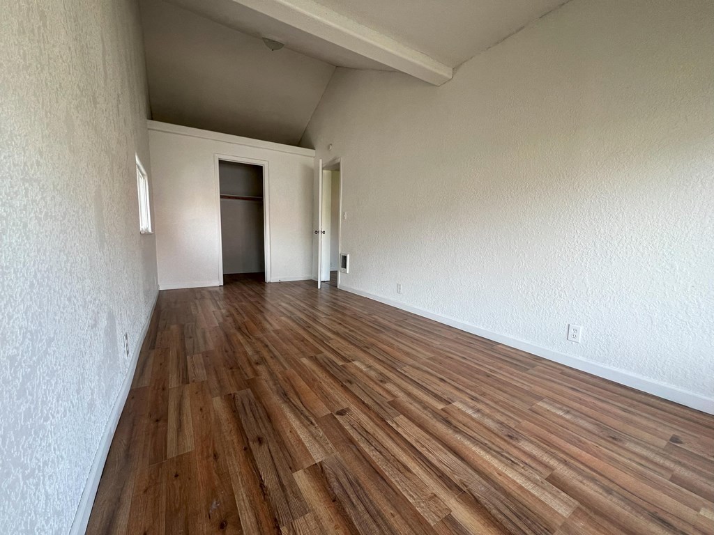 the living room and dining room of an empty house with wood flooring