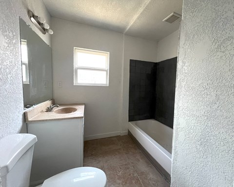 an empty bathroom with a sink toilet and a bath tub