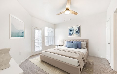 A bedroom with a large bed and a ceiling fan.