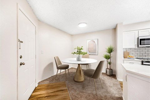 A dining room with a white table and chairs.