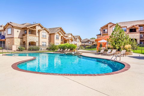 A large swimming pool in front of a row of houses.