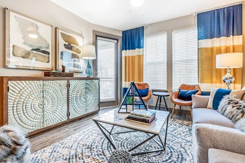 A living room with a glass door cabinet and a rug on the floor.