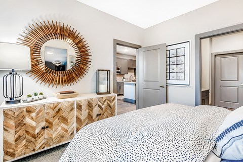 A bedroom with a large bed and a mirror on the wall.