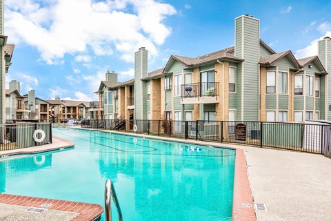 A swimming pool in front of apartment buildings.