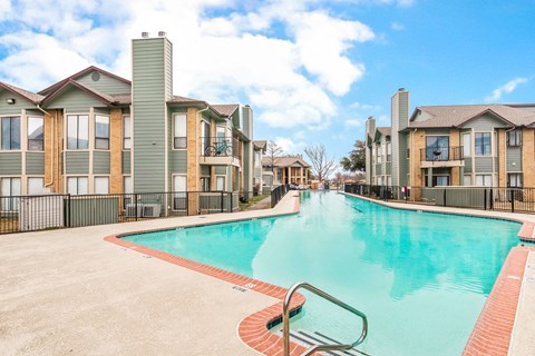 A swimming pool in front of a row of houses.