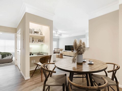 A dining room with a round wooden table and chairs.