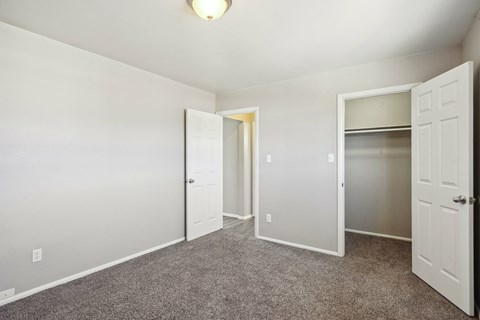 an empty bedroom with a closet and a door to the bathroom