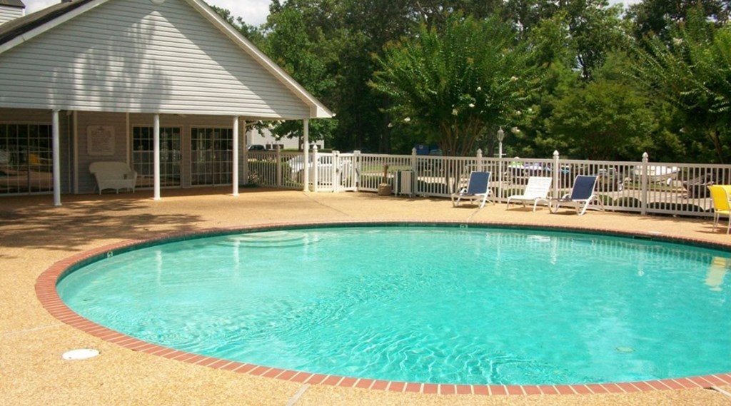 a resort style swimming pool in front of a house