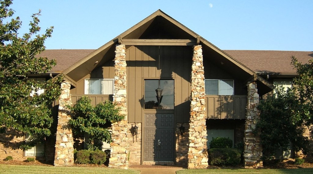 a house with stone pillars and a brown roof