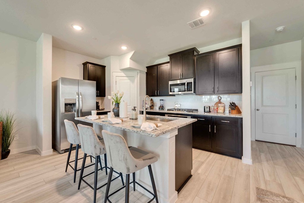 a kitchen with an island with bar stools