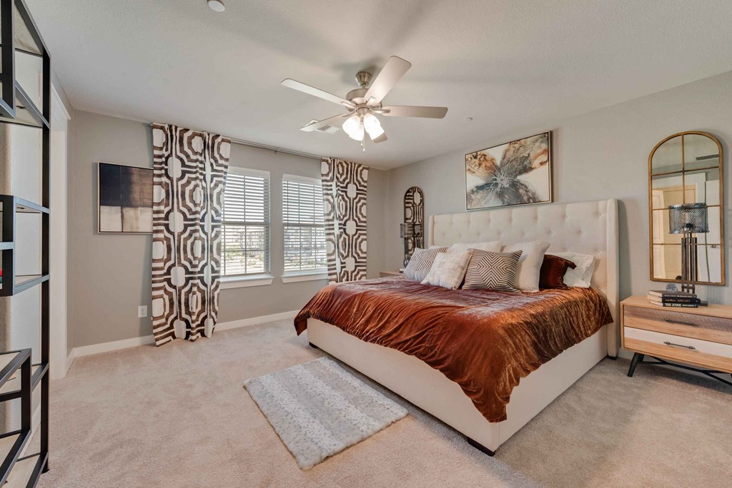 a bedroom with a bed and a ceiling fan