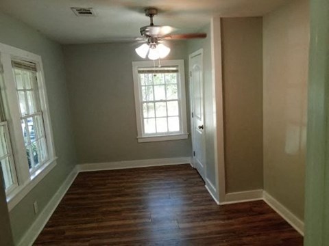 a empty room with a ceiling fan and a window