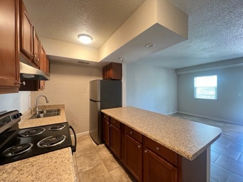 A kitchen with a black stove top oven and a black refrigerator.