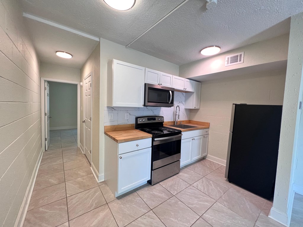 a kitchen with white cabinets and a stove and a refrigerator