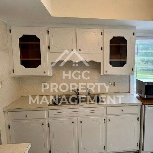 a kitchen with white cabinets and a counter top