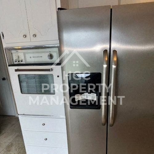 a stainless steel refrigerator and an oven in a kitchen