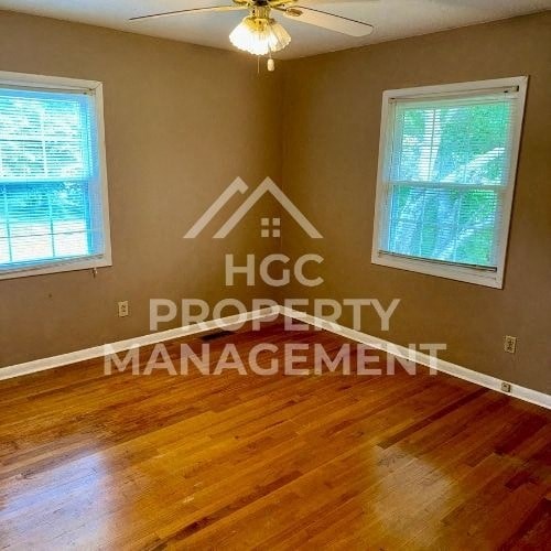 a living room with a hard wood floor and a ceiling fan