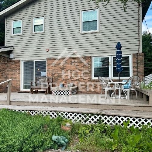 a house with a deck with chairs and an umbrella on it
