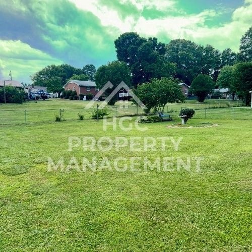 a farm field with houses in the background
