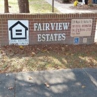 a sign for fairview estates in front of a brick wall
