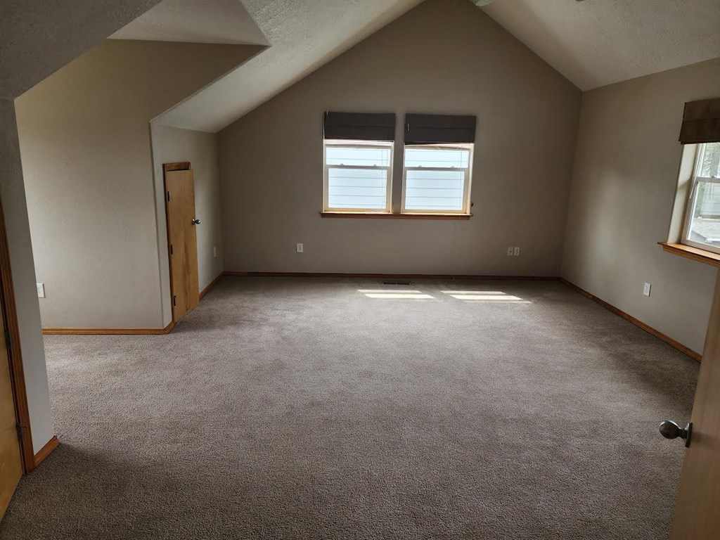 an empty room with two windows and a door