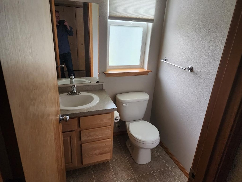 a bathroom with a toilet sink and a mirror