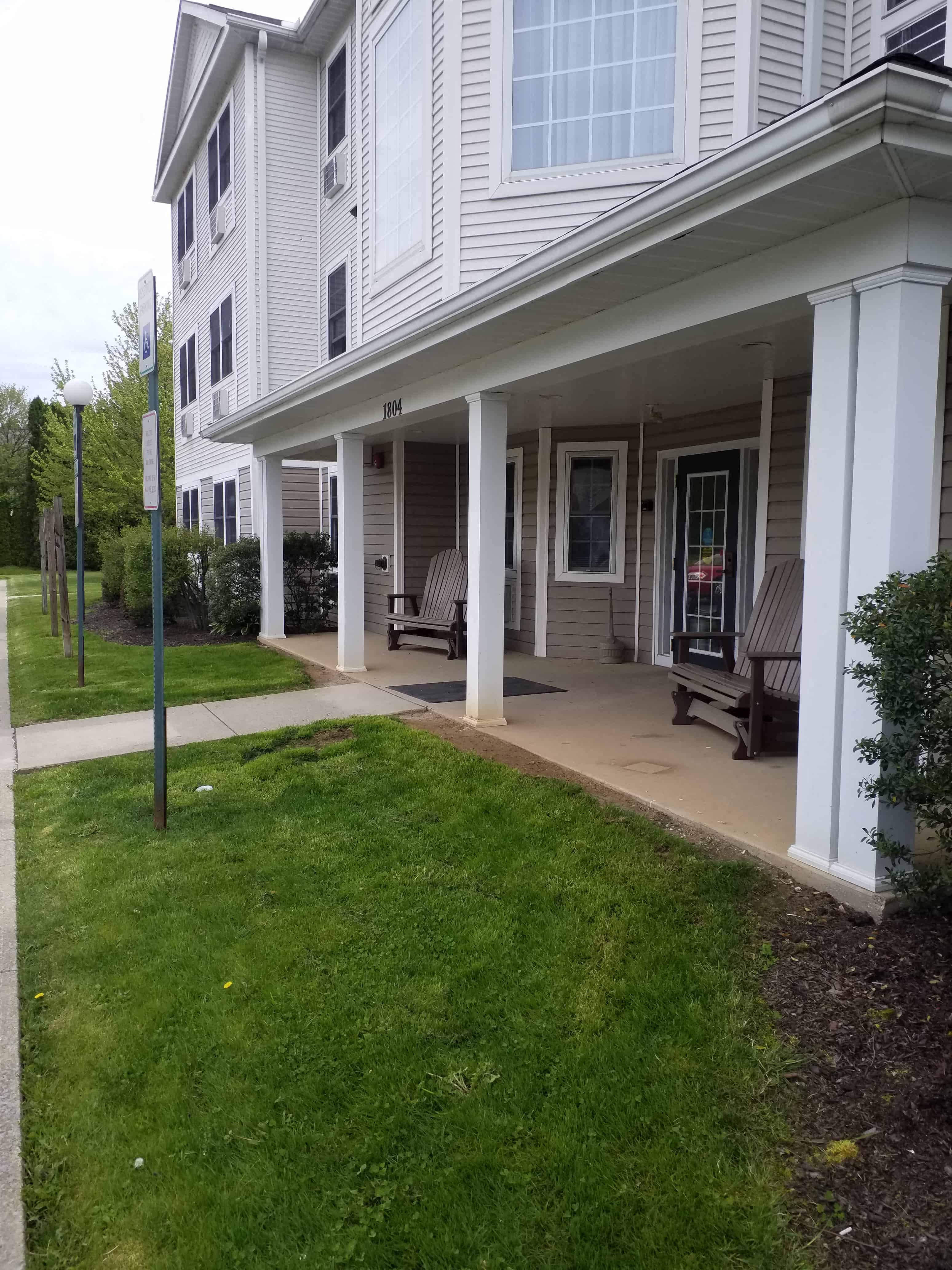 the front of a house with a walkway and lawn