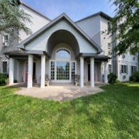 a mansion with a front porch and a lawn