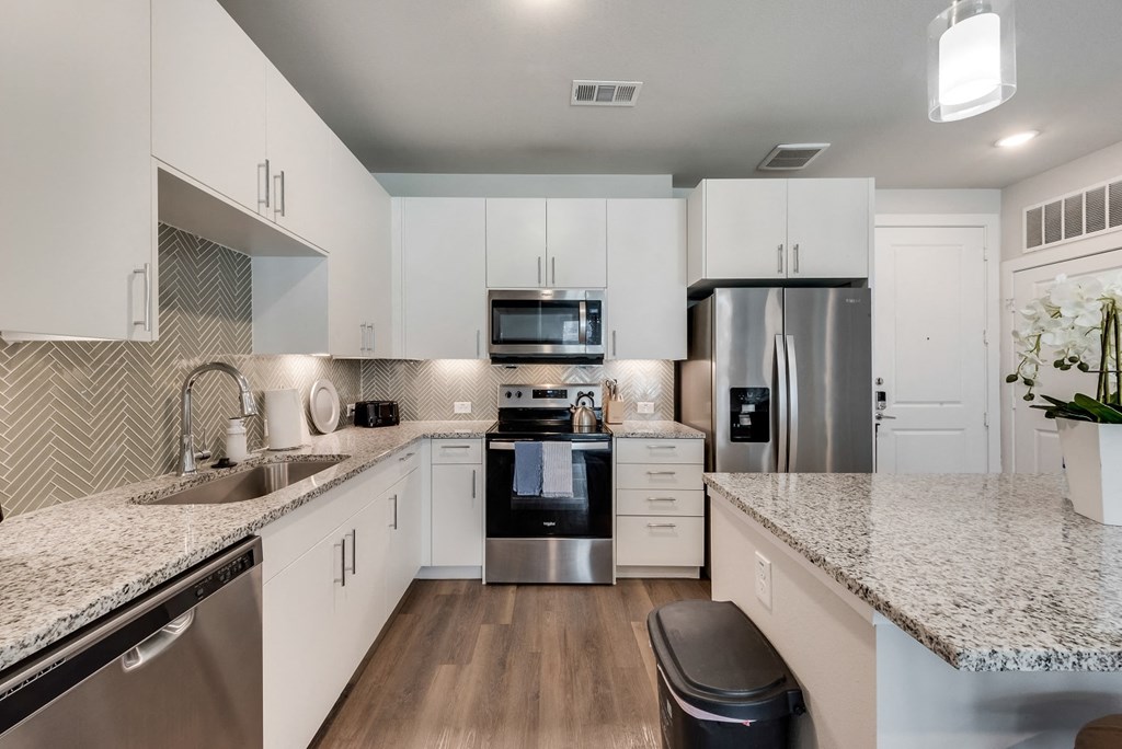 an open kitchen with granite counter tops and stainless steel appliances