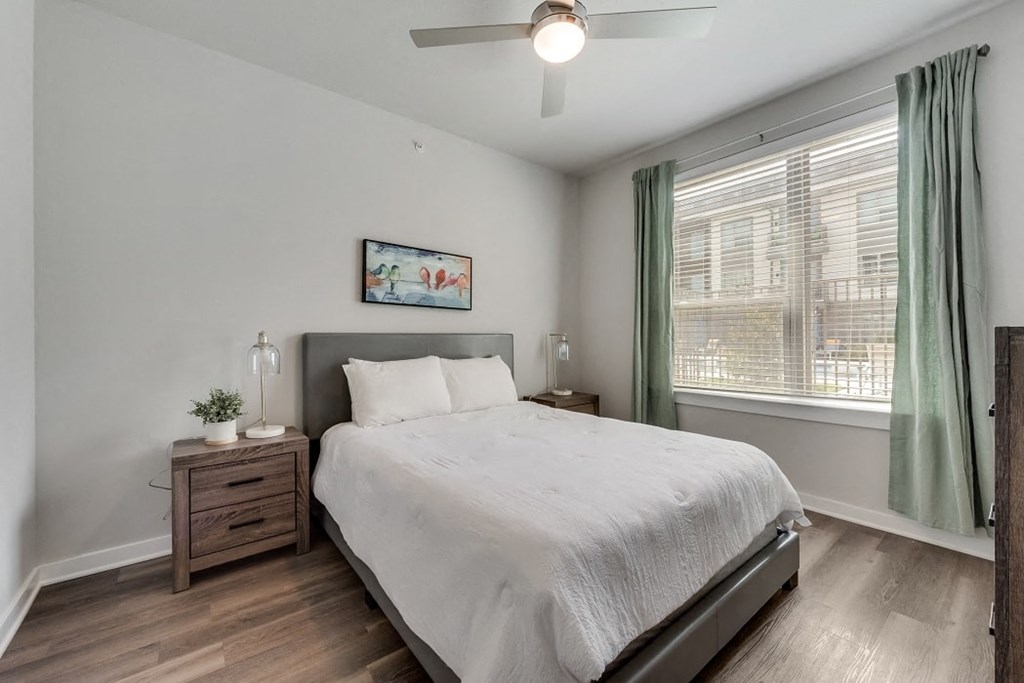 a bedroom with a bed and a ceiling fan