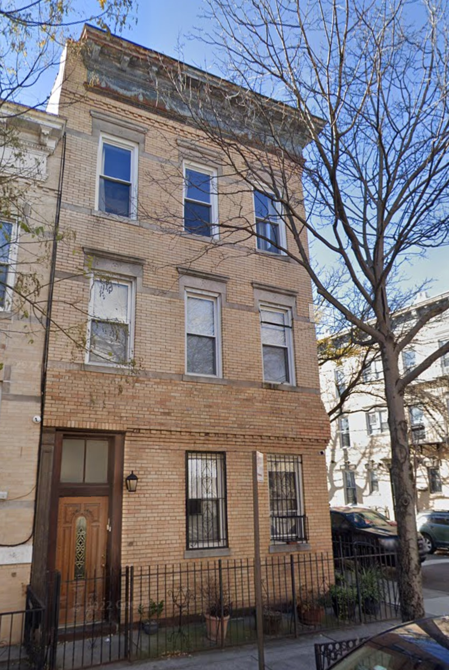 a tall brick building with a tree in front of it