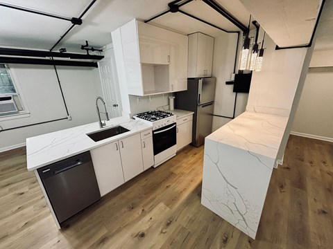 A kitchen with white cabinets and a black fridge.